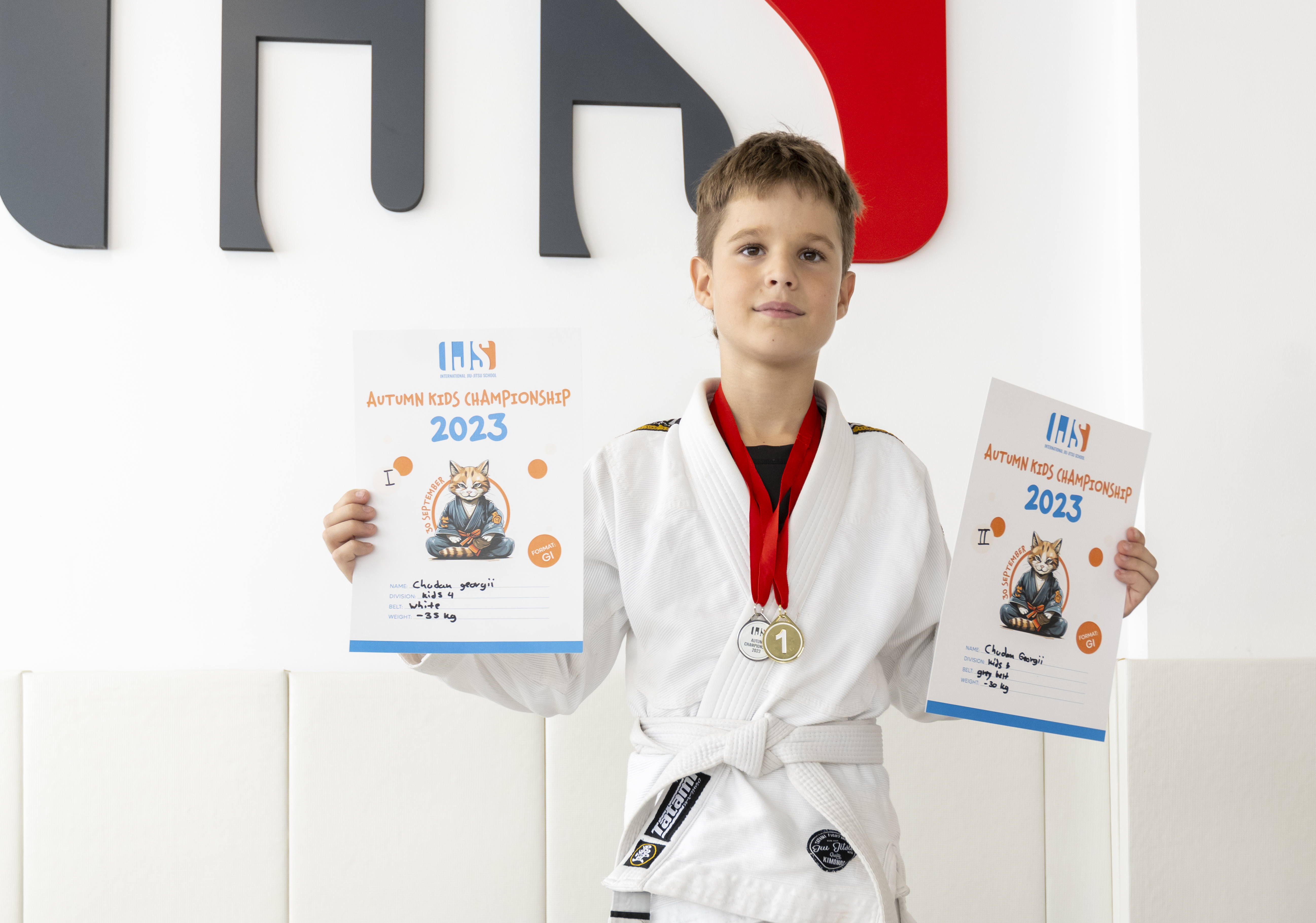 Boy with two championship certificates and medals